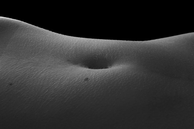Das Bild zeigt den Bauchnabel einer Frau und dient als Titelbild für das Thema „Erogene Zonen der Frau“.