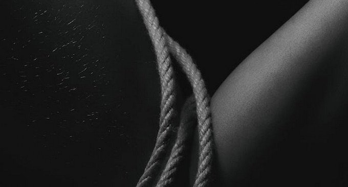 Das Foto zeigt ein Shibari Seil auf der Haut einer gefesselten Person.