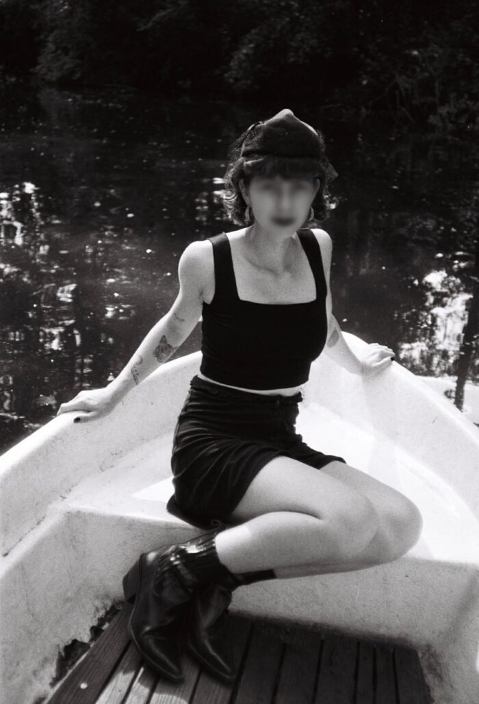 Das schwarzweiss Bild zeigt die junge Frau in einem Boot auf einem See.