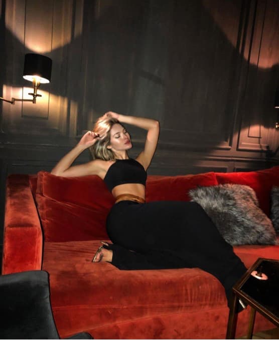 Das-Escort-Camila-posiert-auf-einem-samt-roten-Sofa