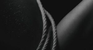 Das Foto zeigt ein Shibari Seil auf der Haut einer gefesselten Person.