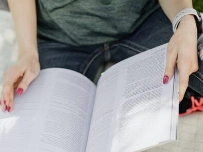 Das Bild zeigt eine junge rau beim Lesen.